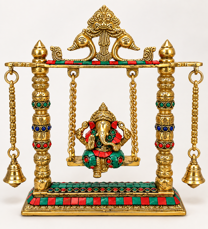 Ganesh Ji seated on a gold-finish decorative jhula with hanging bells and colourful accents