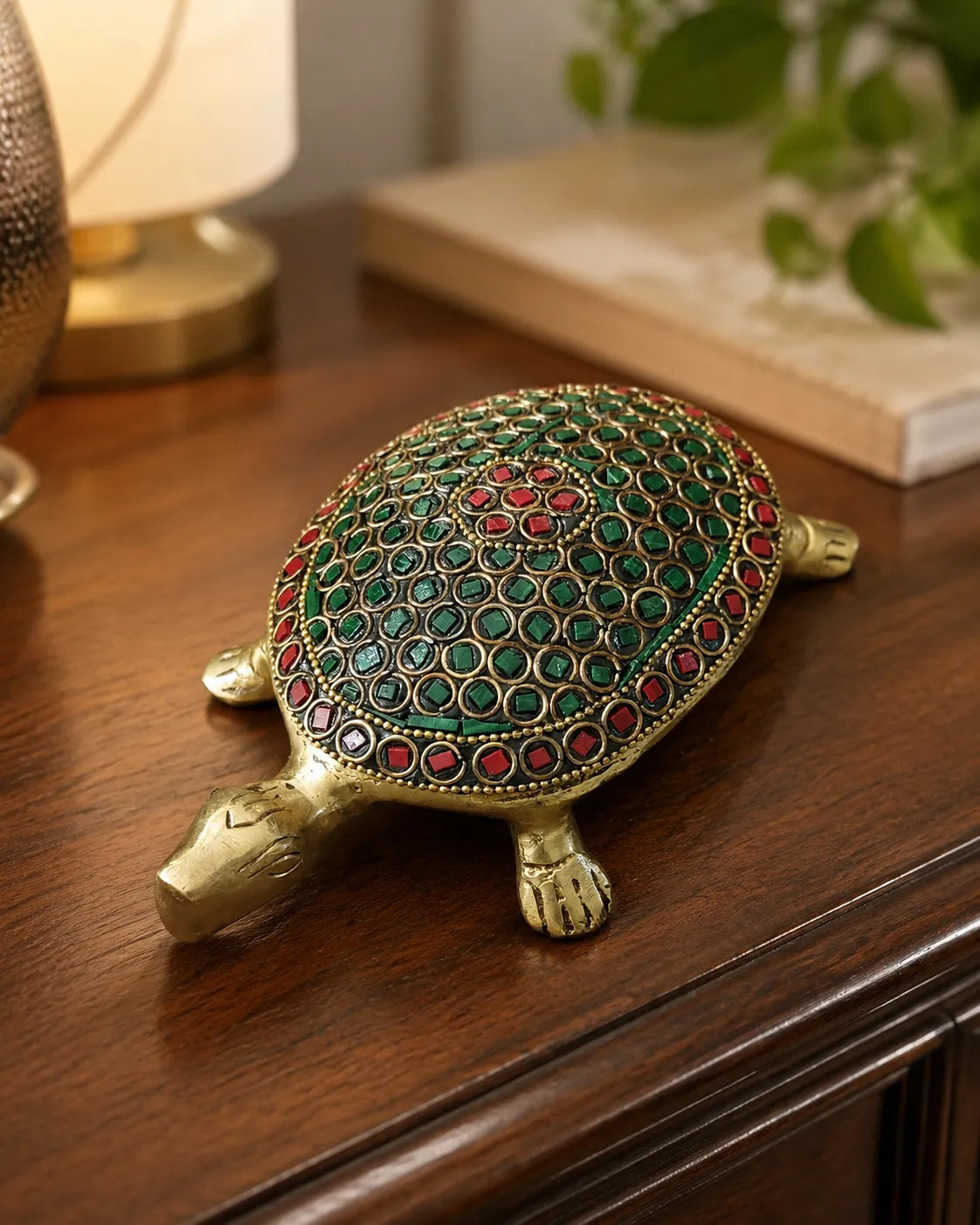 Closeup of red and green stone work on Brass Tortoise shell